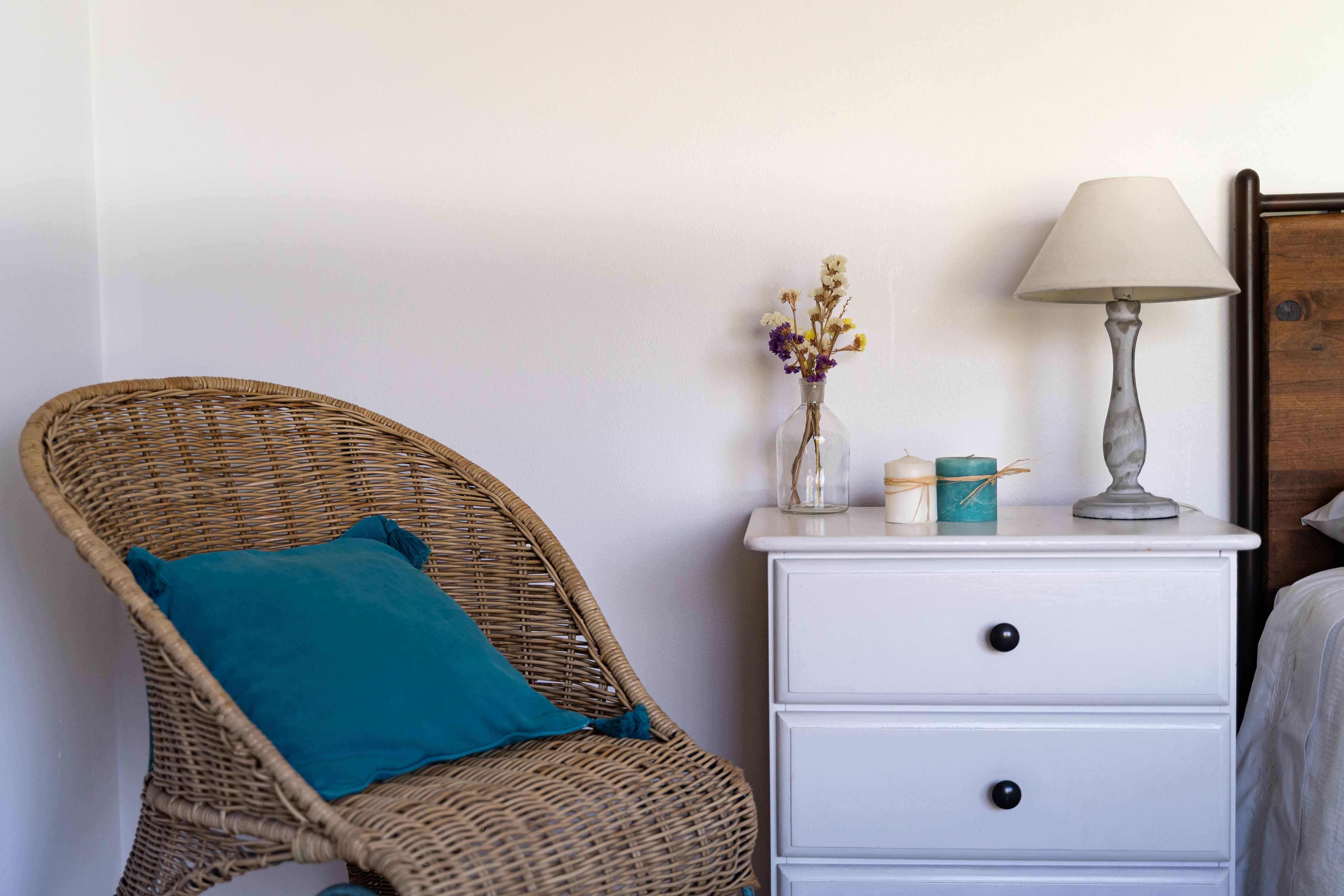 Mesa de cabeceira com flores e candeeiro
